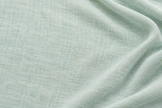 Textura de linho verde-água com fios claros entrelaçados, dobras suaves à direita e iluminação difusa.
