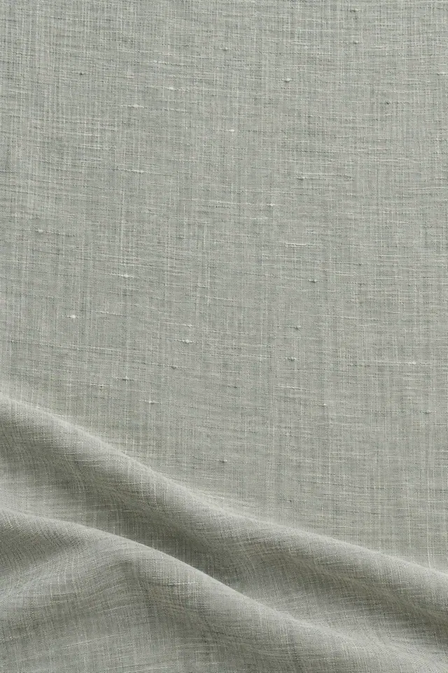Textura de linho verde-sálvia acinzentado, com trama aparente, área ampla e dobras suaves na parte inferior.