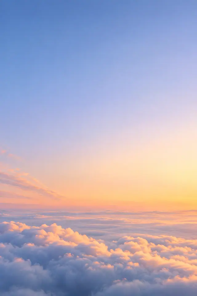 Nuvens fofas iluminadas pelo amanhecer sob um céu amplo em tons de azul, lilás e dourado.
