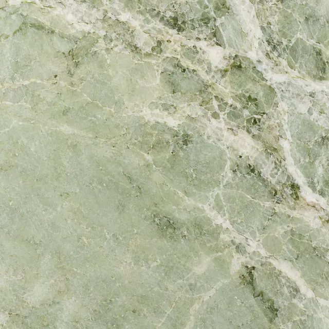 Textura de mármore verde-claro com veios brancos ramificados e pequenas manchas em verde-musgo.
