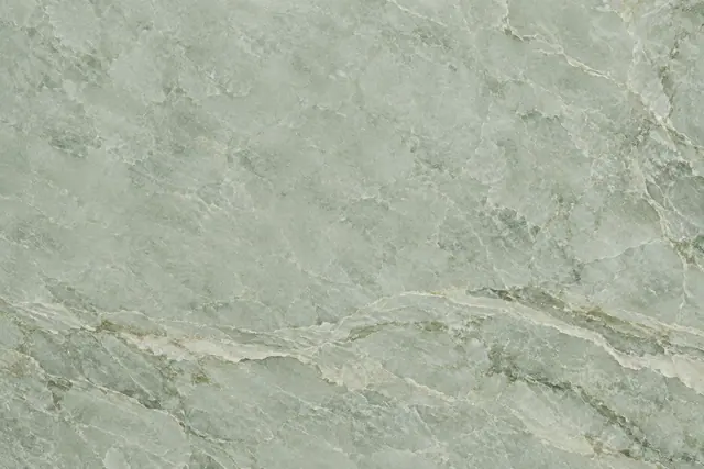 Textura de mármore verde-sálvia com veios de marfim e oliva, mais marcados na parte inferior.