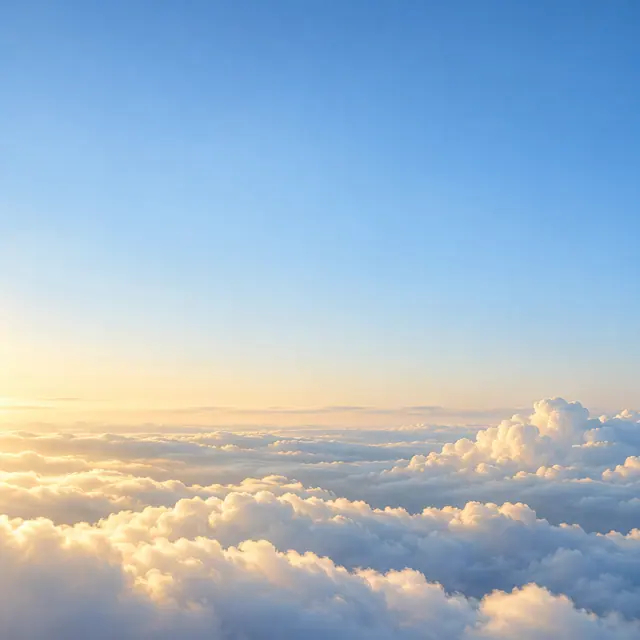 Nuvens brancas com bordas douradas ao amanhecer, sob um amplo céu azul com espaço livre para mensagens.